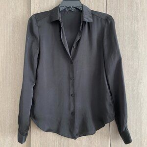 Designed in a lightweight, semi-sheer fabric, it features a classic collared nec